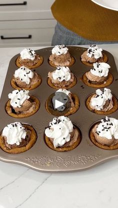 cupcakes with frosting and sprinkles in a muffin tin