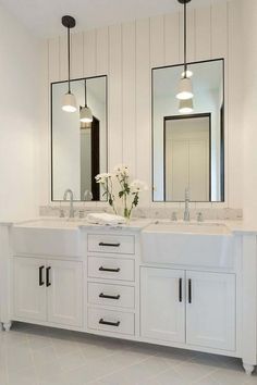 a bathroom with double sinks and two mirrors on the wall next to eachother