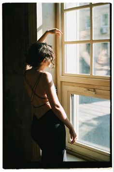 a woman standing in front of a window