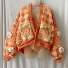 an orange and white sweater with flowers on it