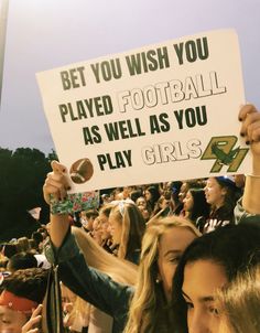 a group of people holding up signs at a football game