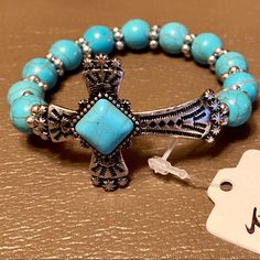 Southwest Turquoise Bead Cross Bracelet Elevate Your Everyday Style - And Beautifully Display Your Faith - With This Lovely Southwest Style Cross Bracelet. A Stunning Spiritual Style, Stretch Bracelet Beautifully Enhanced By Exquisite Color To Elevate Any Ensemble. Featuring Lustrous Compressed Turquoise Beads With A Religious, Sideways Cross Motif At Center. Measure: 6.75 Inch L X 0.94 Inch W, Weight: 21.74 Grams Stone: 10 Mm, Material: Alloy, Rhodium Plating, Compressed Turquoise Turquoise Beaded Stretch Bracelet Gift, Spiritual Turquoise Beaded Stretch Bracelet, Bohemian Blue Jewelry With 8mm Beads, Adjustable Turquoise Rosary Bracelet With Round Beads, Turquoise Stretch Bracelet With Colorful Beads As A Gift, Turquoise Beaded Bracelets With 8mm Beads, Adjustable Turquoise Stretch Bracelet For Jewelry Making, Turquoise Hand-strung Stretch Bracelet, Turquoise Beaded Rosary Bracelet With Round Beads