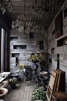 a room filled with lots of vases and potted plants next to a window