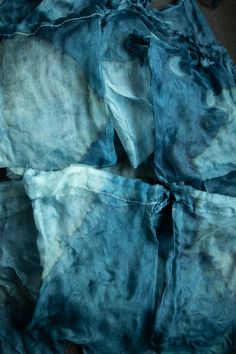 several pieces of blue dyed fabric are stacked together on top of each other in this image