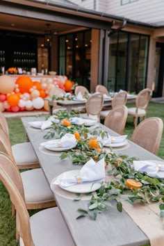 a long table set up with plates and napkins for an outdoor dinner or party