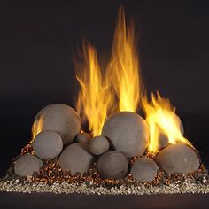 a pile of rocks sitting next to each other on top of a fire pit with flames coming out of them