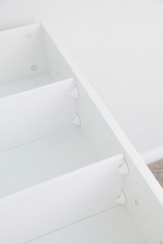 an empty white shelf with three drawers