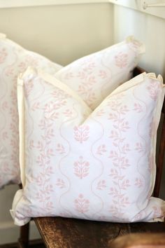 two pillows sitting on top of a wooden chair