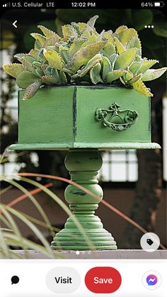 a green planter with succulents in it sitting on top of a table