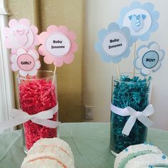 two vases filled with baby items on top of a table