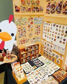 a table topped with lots of magnets next to a chicken head on top of a wall