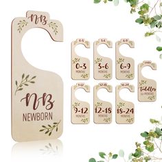 wooden door hangers with names and date printed on them, surrounded by greenery