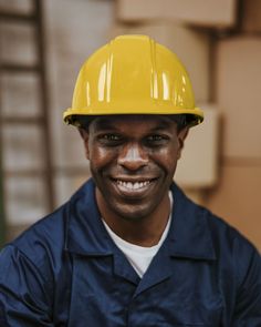 a man wearing a yellow hard hat smiling