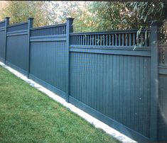 a blue fence in the grass next to a tree