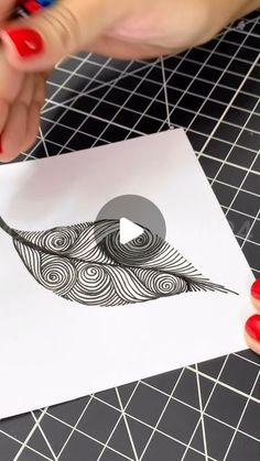 someone is cutting out an image with scissors on a piece of paper that looks like a feather