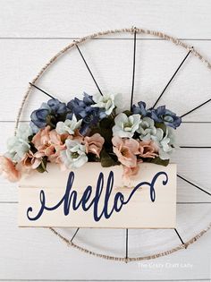 a wooden sign that says hello with flowers in it