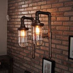 two lights are hanging on the brick wall