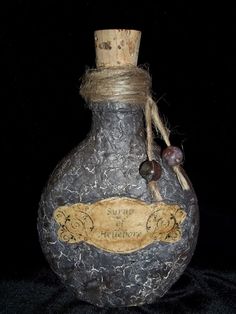 a bottle that is sitting on a black surface with some string attached to the top