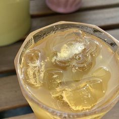 a glass filled with liquid sitting on top of a wooden table