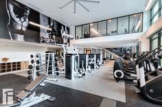 a large gym with treadmills, exercise machines and other personal equipment in it