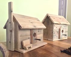 two wooden bird houses sitting on top of a table