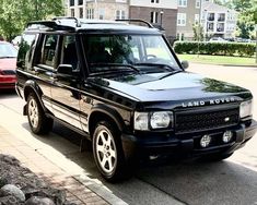 a black land rover parked on the side of the road