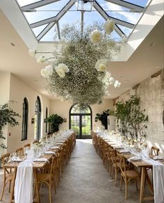 an indoor dining area with tables and chairs set up for a formal function in front of a skylight