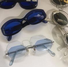 three pairs of blue sunglasses sitting on top of a white table next to each other