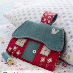 a small purse sitting on top of a bed next to pillows and pillowcases