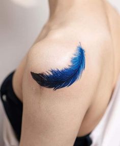 a woman with a blue feather tattoo on her shoulder