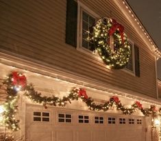 christmas lights on the side of a house with a wreath hanging from it's roof