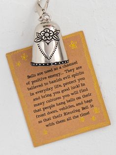 a bell shaped keychain with a poem on it