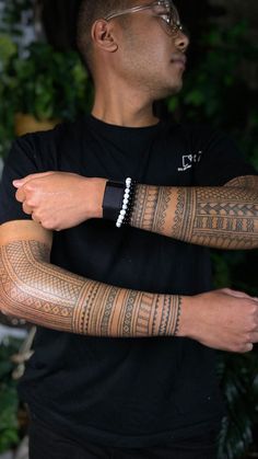 a man with tattoos on his arm and wrist