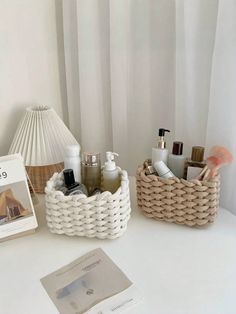 a white table topped with two baskets filled with personal care items and a book on top of it