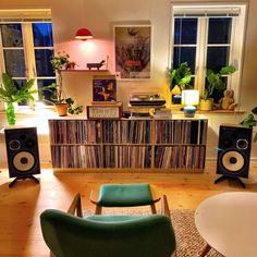 a living room filled with lots of furniture and bookshelves covered in vinyl records