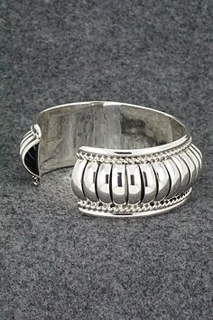 This beautiful and substantial sterling silver bracelet was made by Navajo silversmith Manuel Johnson. The inside is signed MJ and stamped sterling.Size: 5 1/2" (will fit up to a 6 1/2" wrist)Gap: 1"Width: 7/8"Free shipping on all orders! We ship with USPS and always include tracking. All orders ship within a day of payment.Returns are accepted up to 30 days after you receive your order. Just send us a message. Our shop offers cash back or store credit. The item must be returned in new condition Bohemian Sterling Silver Cuff Bracelet With Jubilee Design, Sterling Silver Jubilee Cuff Bracelet, Silver Southwestern Style Cuff Bracelet For Formal Occasions, Southwestern Sterling Silver Polished Bangle Bracelet, Southwestern Sterling Silver Bangle With Polished Finish, Southwestern Polished Sterling Silver Bangle, Silver Southwestern Style Bracelet With Oyster Clasp, Silver Southwestern Style Oyster Bracelet, Southwestern Style Silver Oyster Bracelet