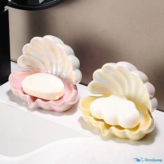 two soap dishes sitting on top of a sink