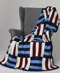 a blue and red blanket sitting on top of a chair next to a gray chair