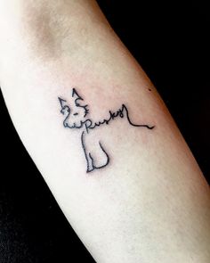 a small dog tattoo on the left forearm and arm, which is drawn in black ink