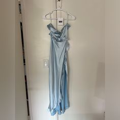 a blue dress hanging on a white wall