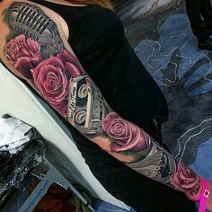 a woman with a tattoo on her arm is sitting in front of a microphone and roses