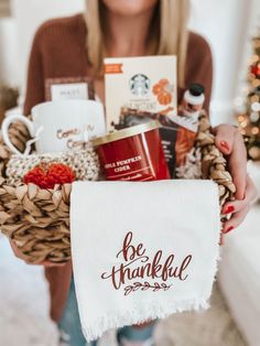 a woman holding a basket filled with coffee, tea and other items in her hands