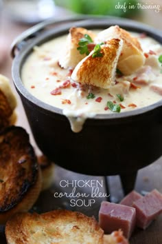 a bowl of soup with bread and garnish on the side, ready to be eaten