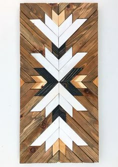 a wooden wall hanging with white and black arrows