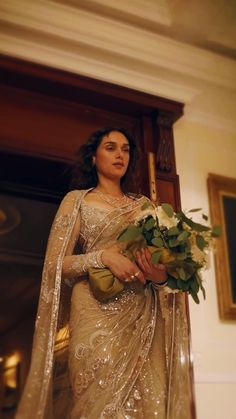 a woman in a sari holding flowers