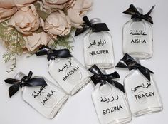 four small glass bottles with names on them