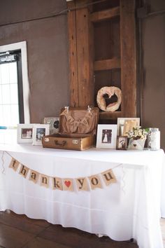 a white table topped with pictures and an old suitcase