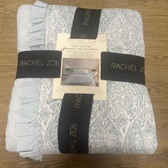 the back of a blue and white bedspread with tags on it