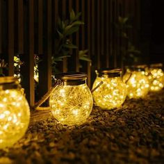 lighted mason jars lined up on the ground