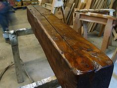 a wooden bench sitting in a room filled with woodworking tools and other furniture items